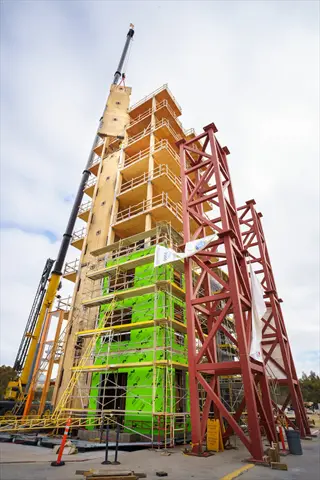 building structural modification during high-rise construction with scaffolding, cranes, and structural steel supports
