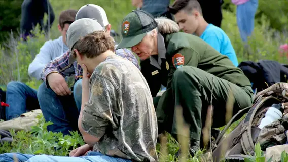 citizen science species monitoring: national park service ranger assisting participants with data recording during field activity in natural habitat