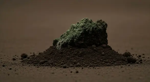 close-up of systemic insecticide granules mixed with soil, forming a small mound with a greenish texture on top