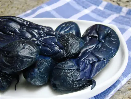 cooked ichiban japanese eggplants served on white plate with blue checkered cloth