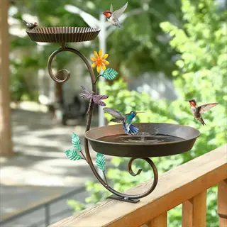 decorative deck mounted bird bath with hummingbirds, metal leaves, dragonfly, and sunflower accents on a wooden railing