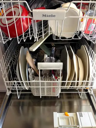dishwasher full load kitchen: miele dishwasher packed with dishes and cookware, demonstrating water-saving tip of running only full appliance loads
