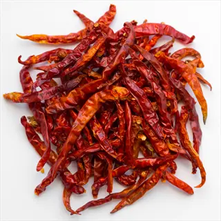 dried thai bird eye chili peppers (thai hot) piled on a white background