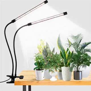 dual-head clip plant grow light with flexible gooseneck arms illuminating various potted houseplants on a wooden table