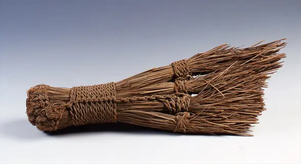 handcrafted natural fiber vegetable cleaning brush with woven binding on plain background