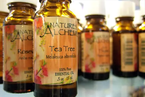 nature's alchemy tea tree essential oil bottles - 100% pure melaleuca alternifolia in amber glass with floral labels