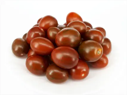 pile of ripe chocolate cherry tomatoes with dark red color and green streaks