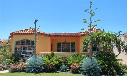 spanish-style house with agave ovatifolia landscape and desert plants under clear blue sky